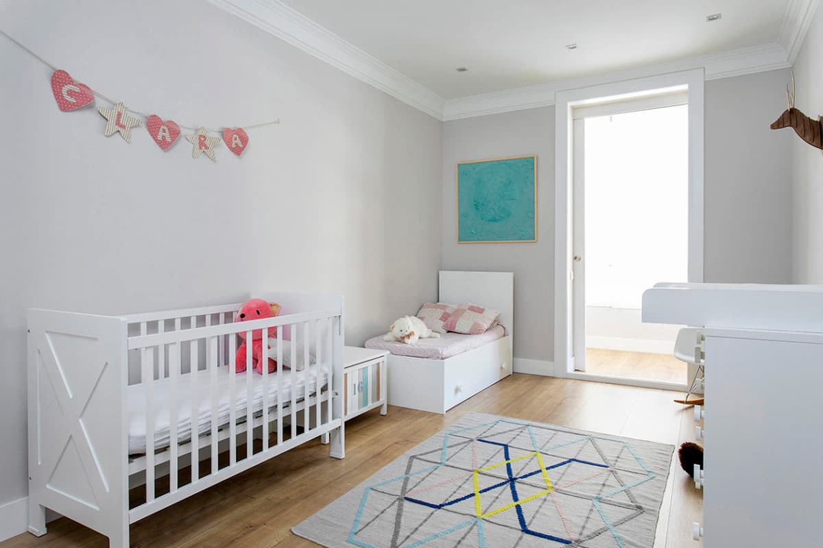 Habitación infantil con una cuna, los muebles para un bebé y decoración infantil. Habitación muy luminosa
