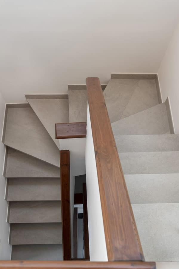 Escaleras circulares con granito y barandilla de madera