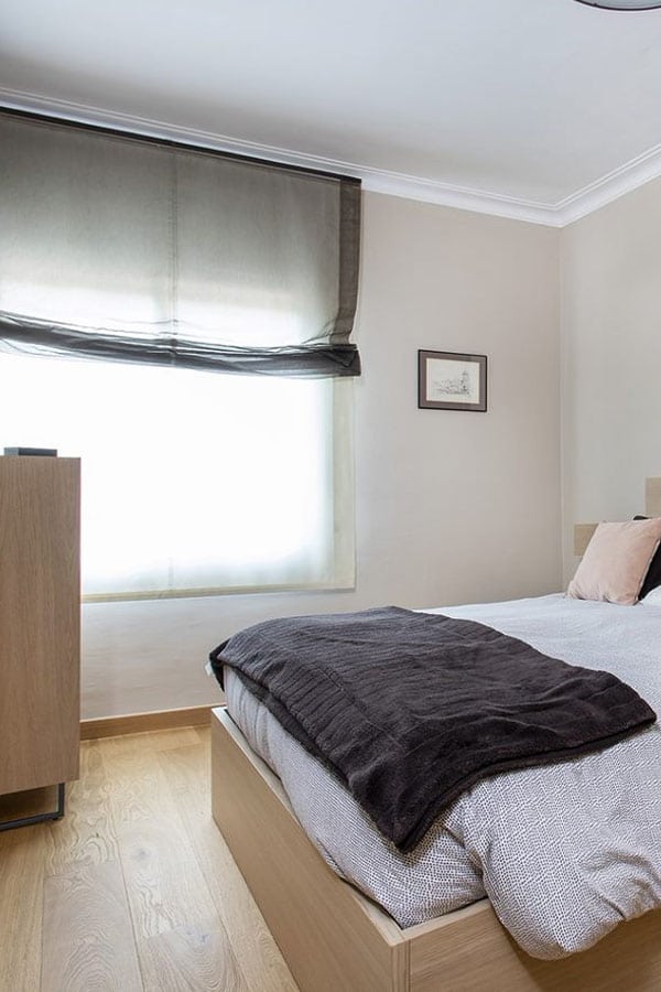 Habitación doble con cama, cómoda y ventana con estor