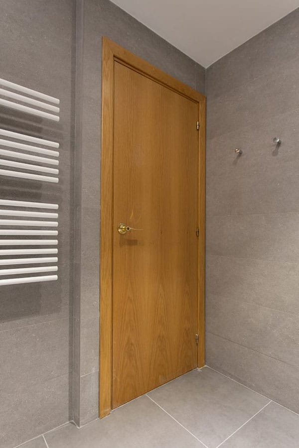 Puerta caoba para baño junto a toallero eléctrico