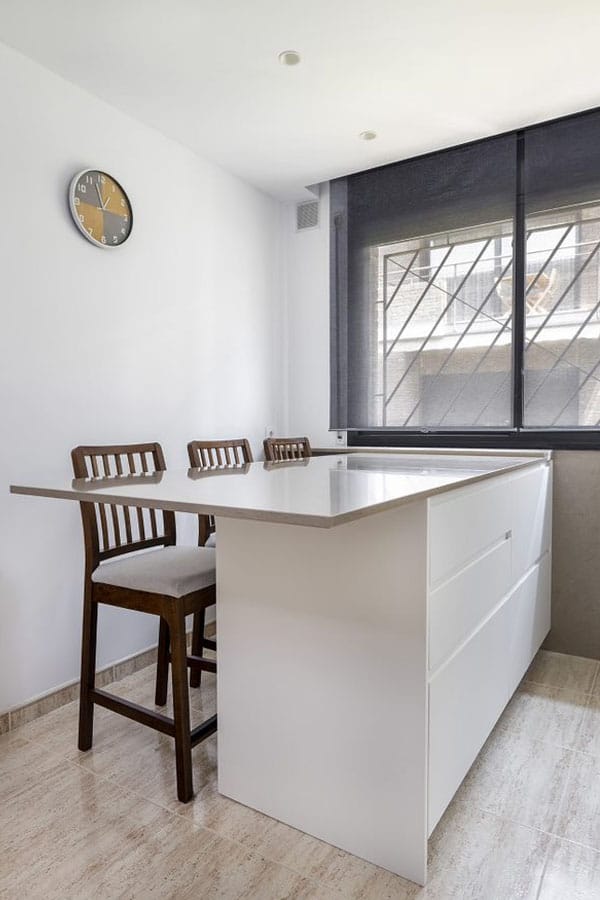 Barra con sillas integrada como parte de una cocina con ventana
