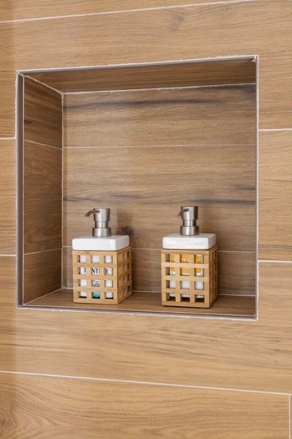 Espacio de almacenamiento integrado en la pared con dos botes de jabón